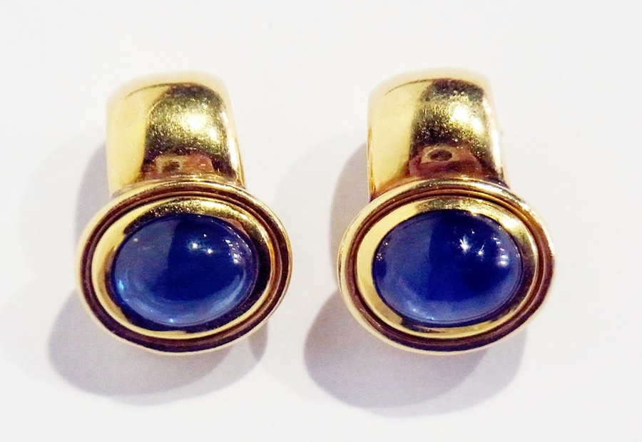 Pair of 18K gold and sapphire earrings, with with cabochon set sapphire set within oval mount