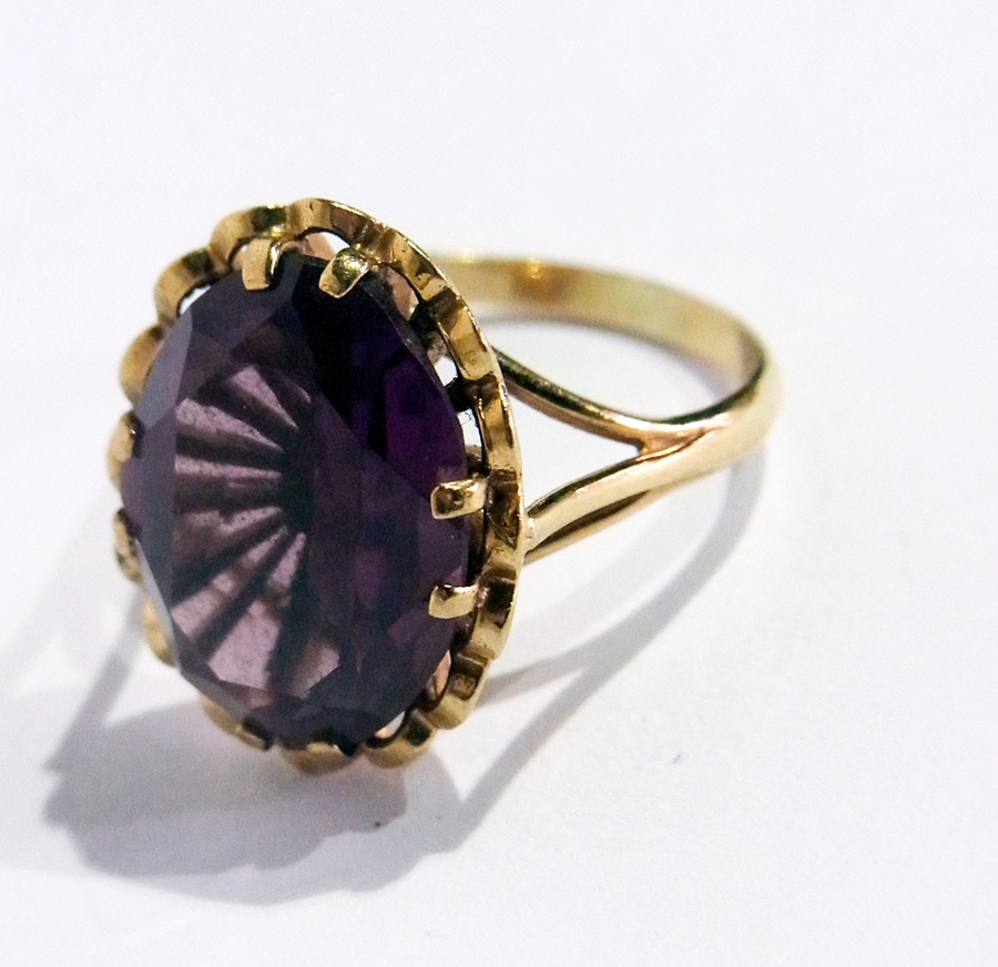 A 9ct gold and amethyst ring set single large facet-cut oval stone