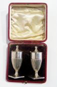 A pair of Victorian silver pepperpots, with bead finials, of reeded urn-shaped form, raised on a