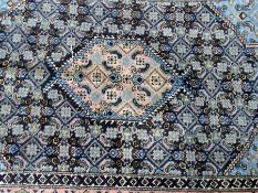 Two Persian wool rugs, the central pink medallion, on midnight-blue ground with pink border and a