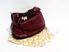 A Radley maroon leather handbag with bead decoration together with dust bag