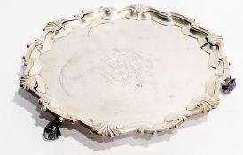 A George II silver salver, with wavy edge border, raised on three foliate scroll legs, London 1750