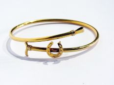 Gold-coloured metal riding crop and horseshoe bangle, 5g approx.