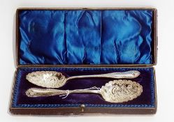 A pair of Victorian silver serving spoons, with repousse scrollwork decoration, Sheffield 1898,