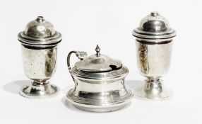A George V silver three-piece cruet set, comprising:- a pair of salt and pepper pots, raised on