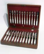 A set of twelve dessert knives and forks, with mother of pearl  handles, with silver hilts, hm