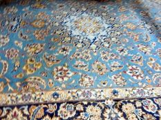 Persian-style wool rug with central flowerhead pattern, medallion on a pale-blue ground, with