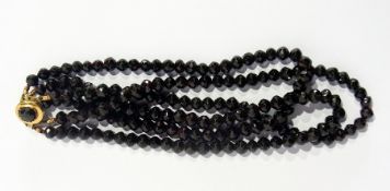 String of faceted garnet type beads with gold-coloured metal clasp