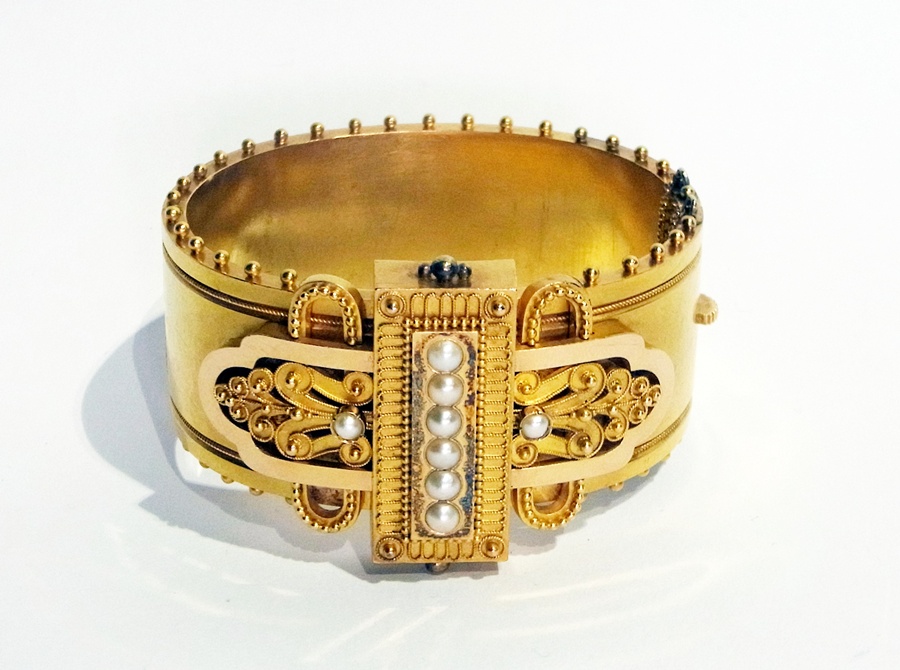 A Victorian gold-coloured metal and pearl Etruscan-style bangle, the central rectangular raised