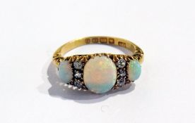 An Edwardian 18ct gold diamond and opal ring set large oval opal, two further oval opals and six old