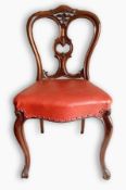 A set of four Victorian mahogany dining chairs with shaped crest rails, carved and pierced splat,