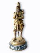 A gilt brass/bronze figure of a legionnaire(?) with full backpack and holding a long barrelled