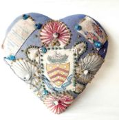 A World War I pin cushion in the form of a heart bearing the crest and arms of the Gloucestershire