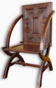 A 19th century oak chair having panelled back and seat, open arms and on 'X' supports