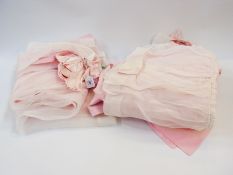 Mid 20th century set of pink satin and white muslin crib covers decorated with satin bows