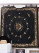 A large black tapestry panel, with gold thread embroidery, fringing, decorated with birds and