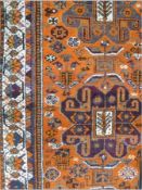 Persian wool carpet, orange ground with red, green, cream border, elephant foot motifs to centre,