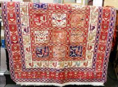 A Soumak carpet, red ground with cream and blue border and square medallions, decorated with