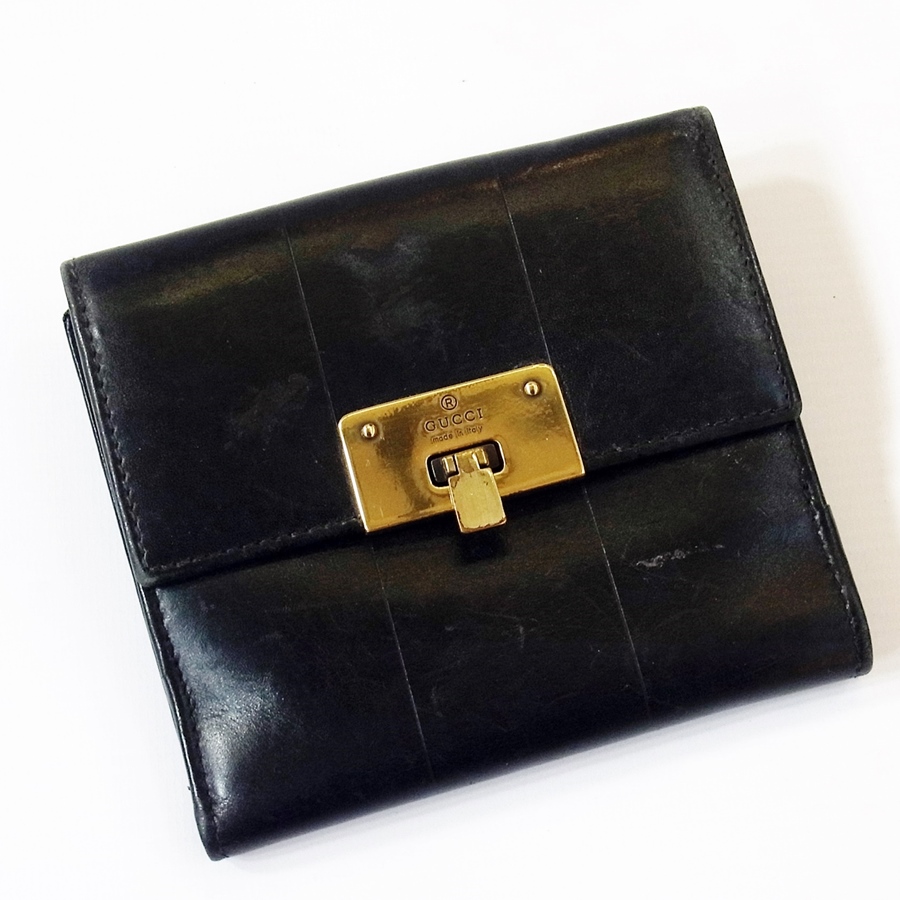 Gucci black leather wallet, with metal clasp, engraved "Gucci, made in Italy"