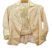 A child's satin jacket, a matching waistcoat and trousers in pale peach with lace ruffle, worn by