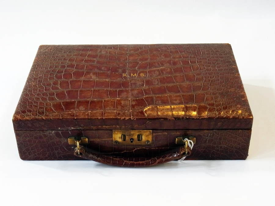 A crocodile travel jewellery case, with hinged lid, with fitted compartments, initialled "K.M.S",