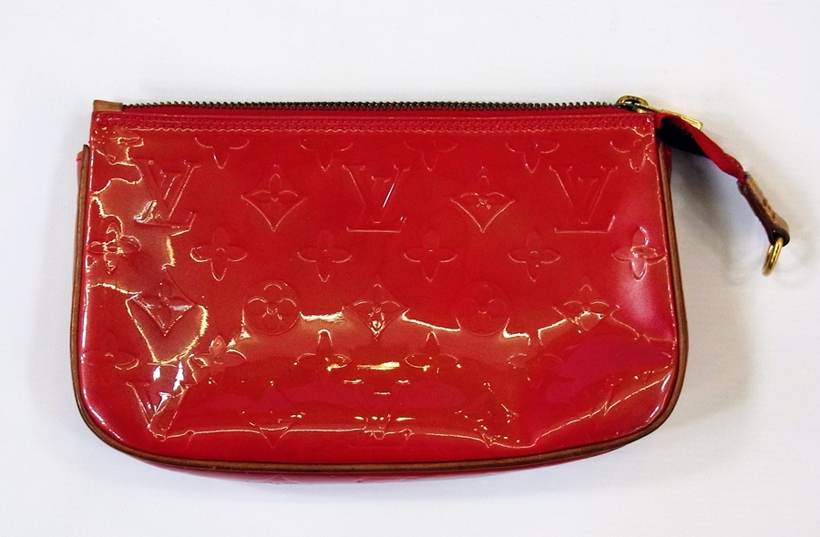 A Louis Vuitton red clutch bag, with zip, monogrammed "LV"