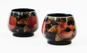 Pair early Moorcroft pottery "Pomegranate" vases, bulbous and footed, each with typical decoration
