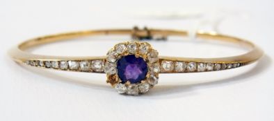 A late Victorian/Edwardian gold-coloured metal, amethyst and diamond bangle, the circular amethyst