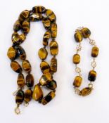 Tiger's eye and gold-coloured metal bracelet, the polished tiger's eye stones interspersed by gold-