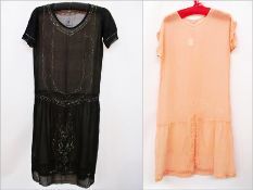 A 1920's beaded black dress and another peach and white beaded chiffon dress