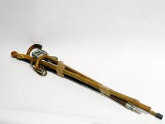 A silver mounted walking stick and several others