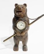 Black Forest carved dancing bear clock, the standing bear holding brass dancing pole and with