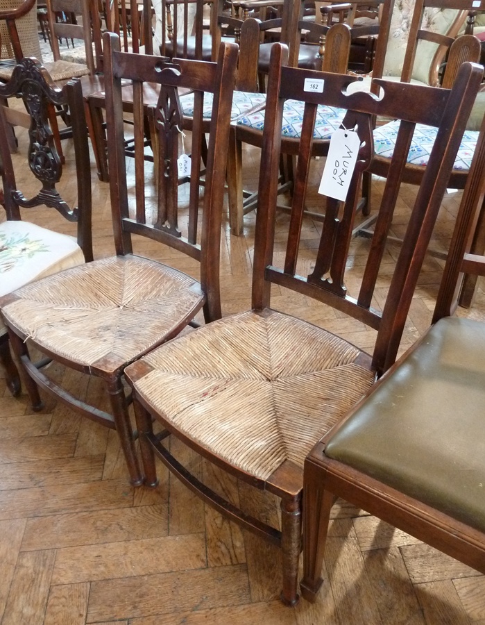 Pair Arts and Crafts style stained wood rush-seated low chairs, having pierced central splat to