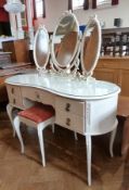 A reproduction white painted kidney-shaped dressing table, with triple mirror back, central frieze