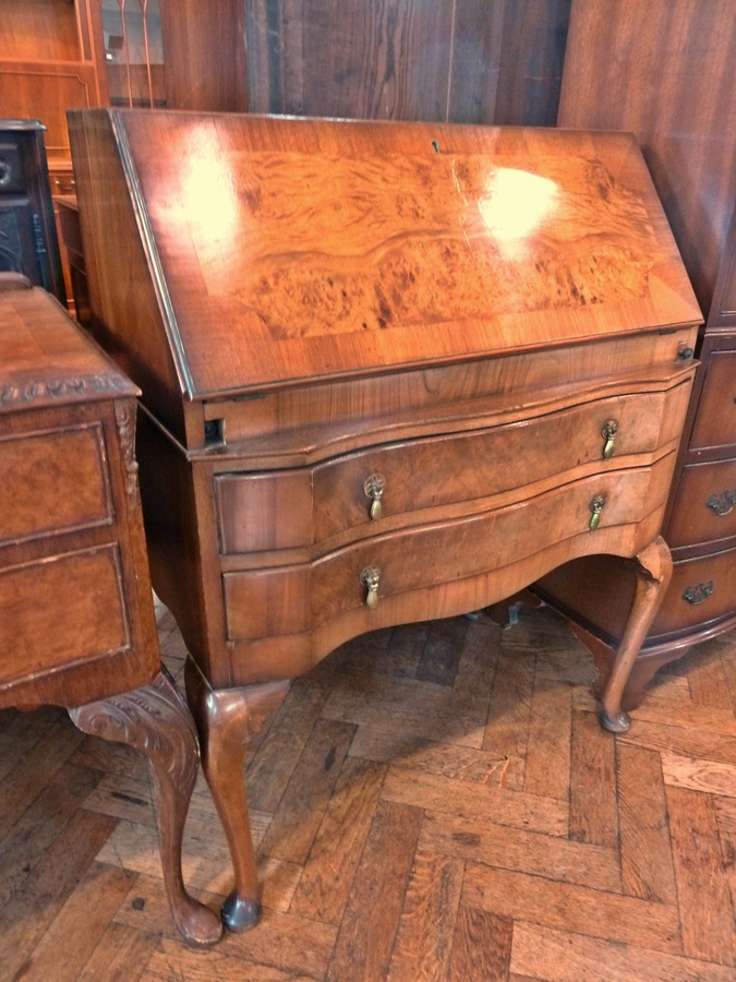 Reproduction figured walnut bureau, having pigeonholes to the interior, serpentine fronted, two