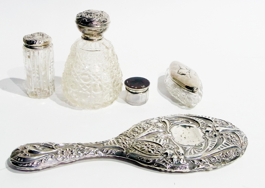 A silver-backed hand mirror, three silver capped glass jars and another of faux-tortoiseshell