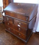 An early 18th century oak bureau in two sections, the fall front enclosing a stepped fitted interior