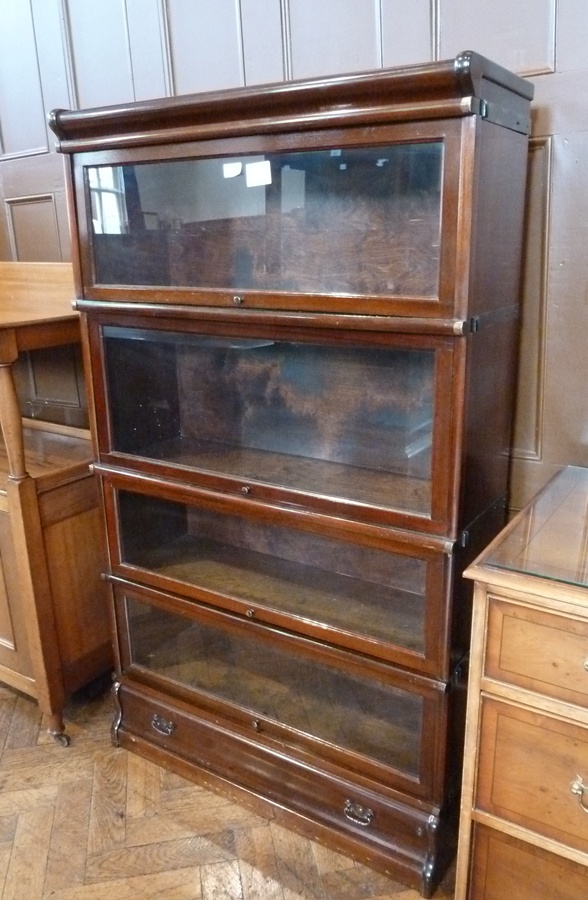 A Globe Wernicke style mahogany sectional glazed bookcase of four shelves, with long drawer below,