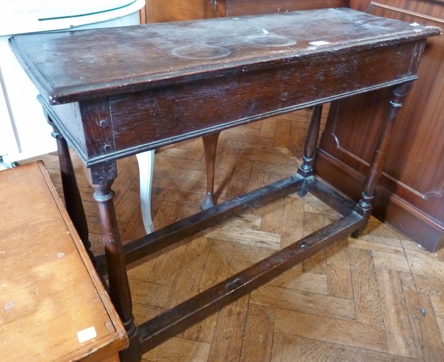 An old oak side table, with moulded edge top, plain frieze, on baluster-turned supports united by