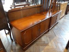 A reproduction yew wood cupboard enclosing adjustable shelves and trays with another and a nest of