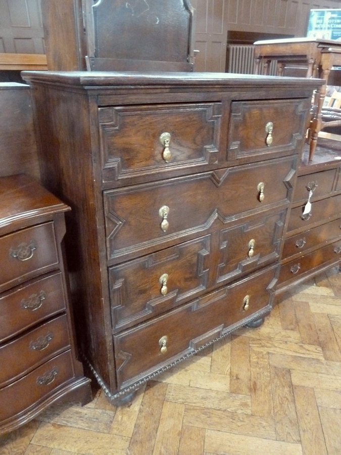 Reproduction 17th century style oak chest of two short and three long graduated drawers, all with