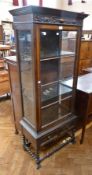 A reproduction Jacobean-style stained oak glazed bookcase, with blind fretwork frieze, the