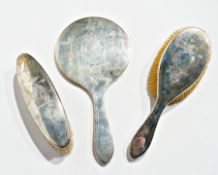 A silver-backed dressing table set comprising a hand mirror, hairbrush and clothes brush, Birmingham