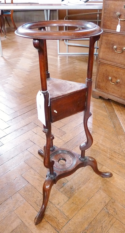 A Georgian mahogany washstand, with open circular top, shelf with cupboard below, on turned scrolled