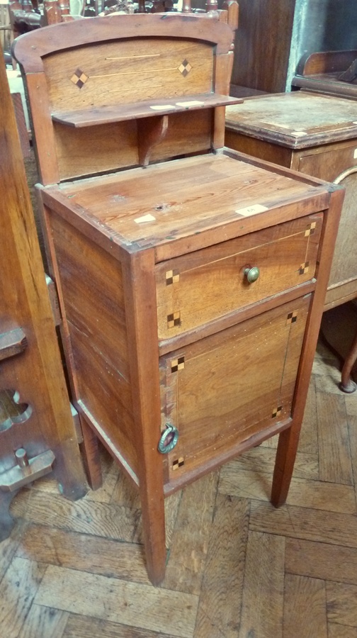 A mid 19th century pine bedside cupboard with shelf back, frieze drawer, cupboard below, chequer