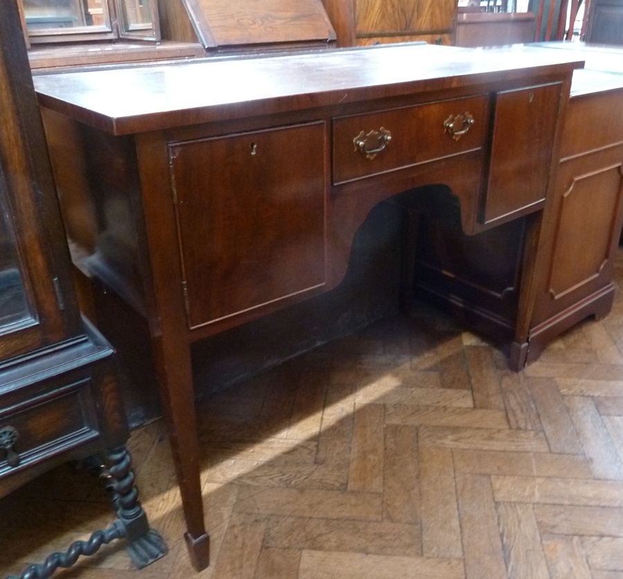 A reproduction mahogany kneehole dressing table, with central frieze drawer, flanked by cupboards,