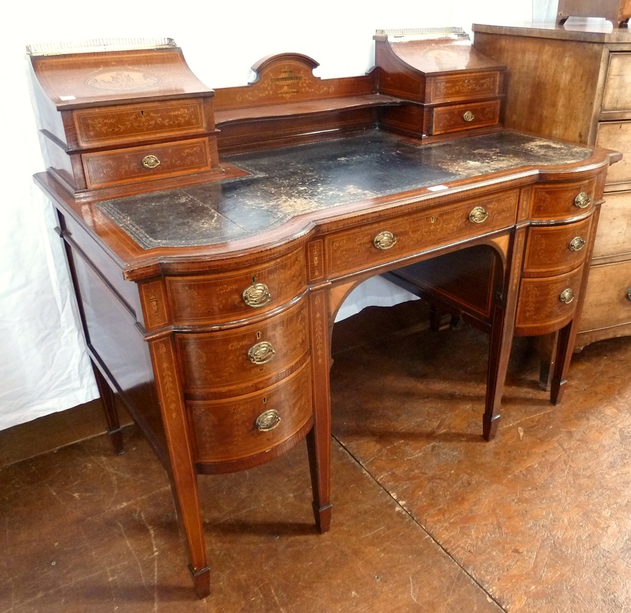 An Edwardian lady's marquetry inlaid mahogany kneehole writing desk, the upper section with