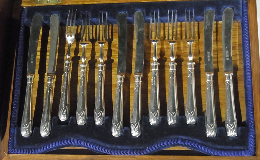 A set of six silver handled fruit knives and forks in fitted case, together with a set of six fish