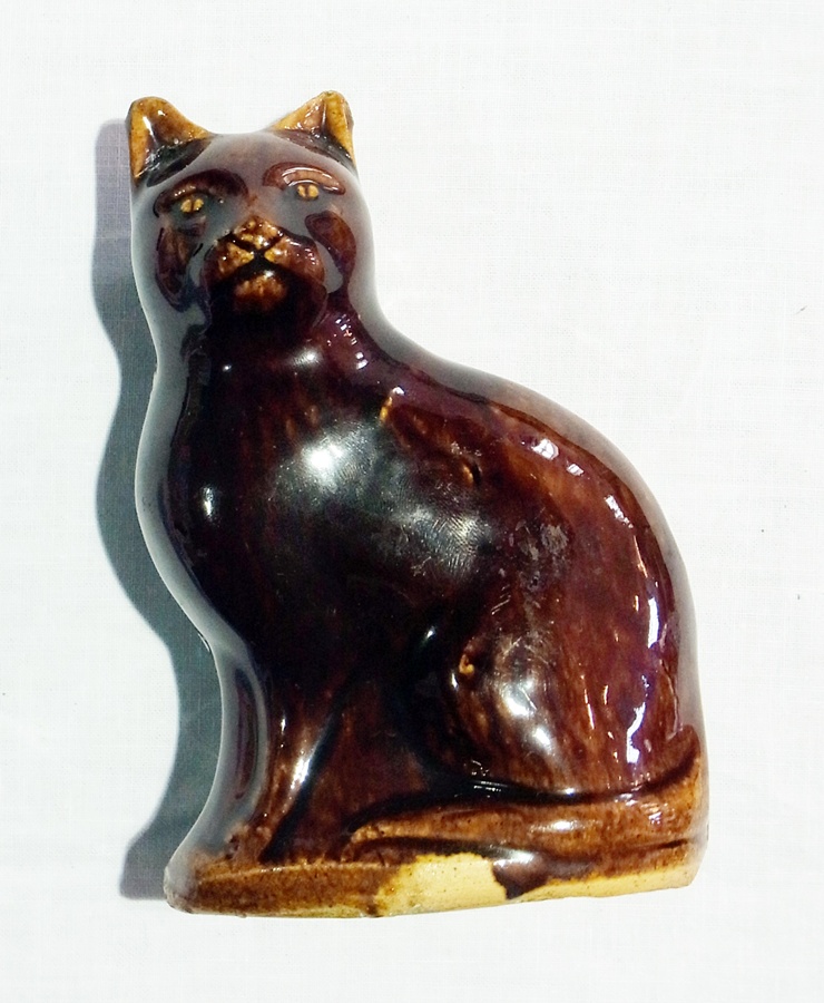 19th century Staffordshire treacle glazed cat money box in the form of seated cat, 13cm high