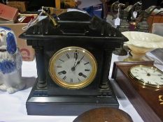 A Victorian mantel clock with slate case, gilt roman numerals raised on a square platform base,